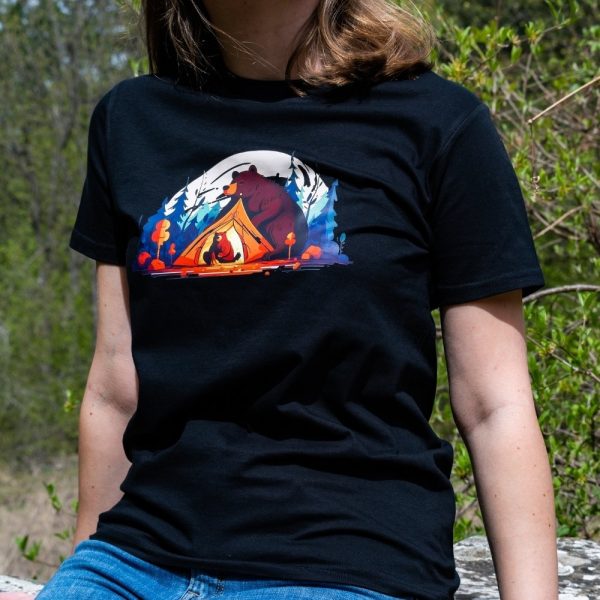 Woman wearing a black unisex T-shirt with a "Bears" design featuring a bear guarding a tent by a campfire in a colorful forest.