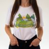 Woman wearing a white unisex T-shirt with a colorful illustration of mountains, trees, clouds, and the sun, featuring the word "Странджа" in Cyrillic.