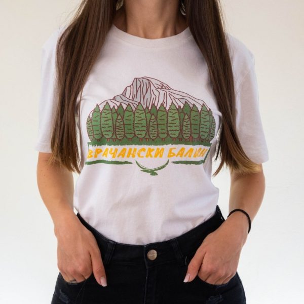 damska-planinarska-teniska-byala-vrachanski-balkan Woman wearing a white unisex T-shirt featuring an illustration of Vrachanski Balkan mountains, trees, and the text "Врачански Балкан" in Cyrillic.