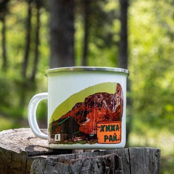 kanche-za-planina-kenche-metalno (2) White enamel camping mug with a colorful illustration of the famous Ray Hut in Stara Planina, placed on a wooden stump with a green forest background.