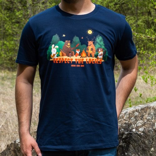 navy-tymno-sinia-teniska-myzhka Man wearing a dark blue unisex T-shirt with a "Respect the Locals" design, featuring forest animals gathered around a campfire.
