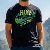 teniska-hike-nike-just-do-it Man wearing a black unisex T-shirt with a "Hike – Just Do It" design, featuring green mountains, a hiker silhouette, and a tent illustration.