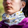 bandana-za-planina-momiche Woman wearing a white multifunctional buff with Bulgarian mountain names and hiking-themed illustrations around her neck.