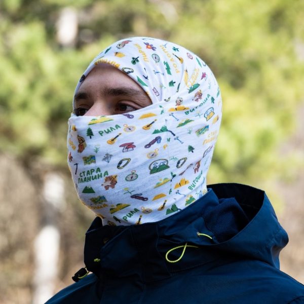 bandana-za-planina-myzhe Man wearing a multifunctional white buff as a full-face balaclava, featuring hiking-themed illustrations and Bulgarian mountain names.
