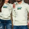 Unisex light green hoodie with an embroidered bear design featuring a scenic mountain landscape.