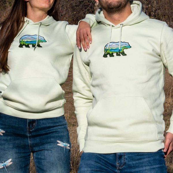 Unisex light green hoodie with an embroidered bear design featuring a scenic mountain landscape.