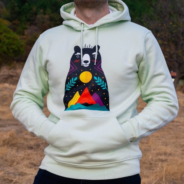 hoodie-sweatshirt-zelen-cvyat-za-momche Light green hoodie with a colorful bear and mountain design, worn by a man outdoors.