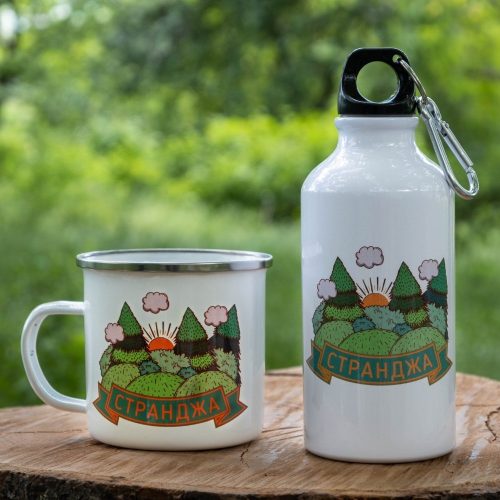 podarak-komplekt-butilka-kanche-strandzha White enamel mug and 400ml aluminum bottle with a green forest design representing Strandzha Mountain, placed on a wooden surface with a natural background.