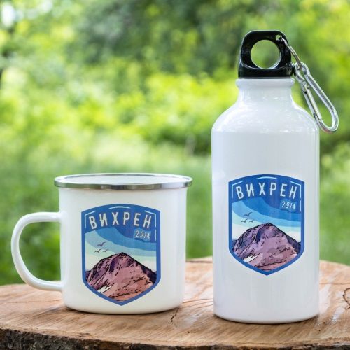 podarak-komplekt-butilka-kanche-vihren White enamel mug and 400ml aluminum bottle with a mountain shield design representing Vihren Peak (2914m), placed on a wooden surface with a green nature background.