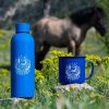 Blue enamel mug and 800ml stainless steel bottle featuring a design of a wooden cabin in the mountains under a starry night sky, symbolizing freedom and adventure.