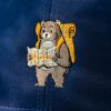 Close-up of embroidered bear with a backpack and a map on a navy blue cap.