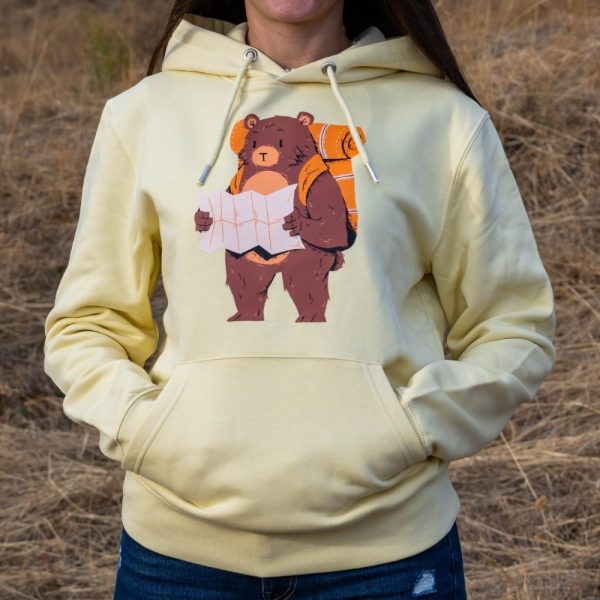 swearshirt-hoodie-zhylto-turist Yellow hoodie with a hiking bear illustration, worn by a woman outdoors.