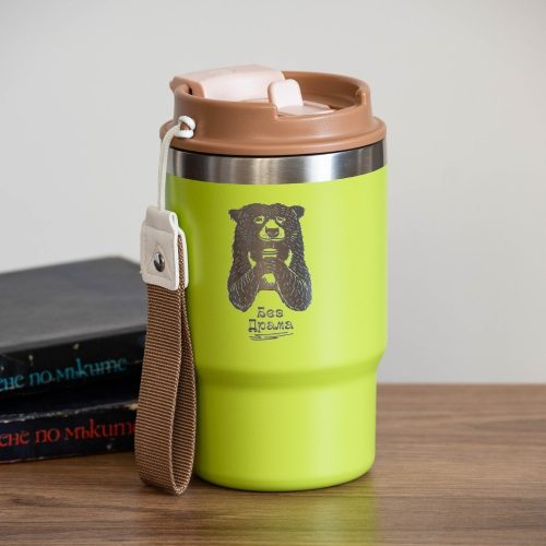 thermo-chasha-za-kafe-chai-lazerno-gravirana Green stainless steel thermal mug with an engraved illustration of a bear holding a cup. Features a durable design, a dual lid with a straw and classic drinking spout, and a carrying strap.