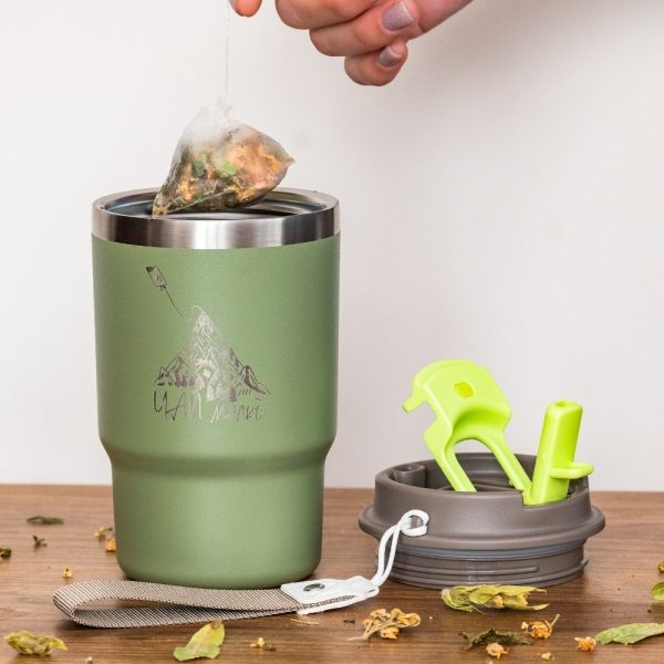Green stainless steel thermal mug with a laser-engraved mountain design and the text "Чай малко." Features a removable insulated lid with a straw and secure seal. Dishwasher safe.