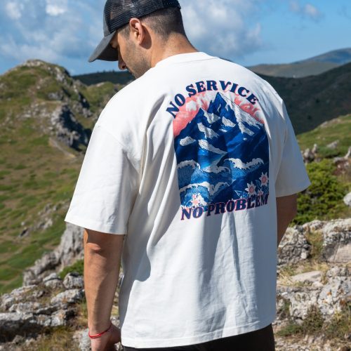 teniska-oversize-shiroki-rakavi-byala- Man wearing oversized organic cotton T-shirt with mountain and sea print "No Service No Problem"