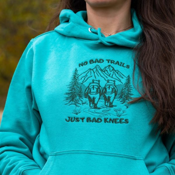 not-bad-trails-just-bad-knee turquoise women's hoodie with quote “No bad trails just bad knees” and embroidered mountain hikers design