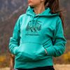 sweatshirt-hoodie-green turquoise women's hoodie with quote “No bad trails just bad knees” worn outdoors with mountain background
