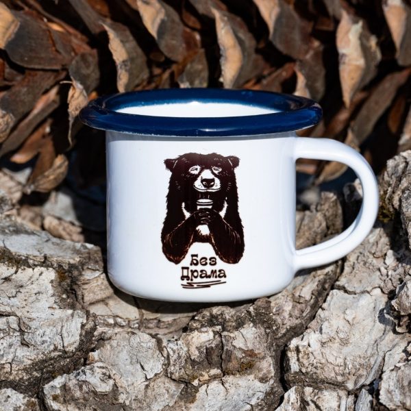 malko-kanche - 100ml White enamel mug with blue rim and black bear illustration holding a cup with the text “No Drama”, placed outdoors on bark.