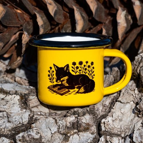 malko-zhylto-kanche Yellow enamel mug with black illustration of a fox reading a book among flowers, placed outdoors on bark.