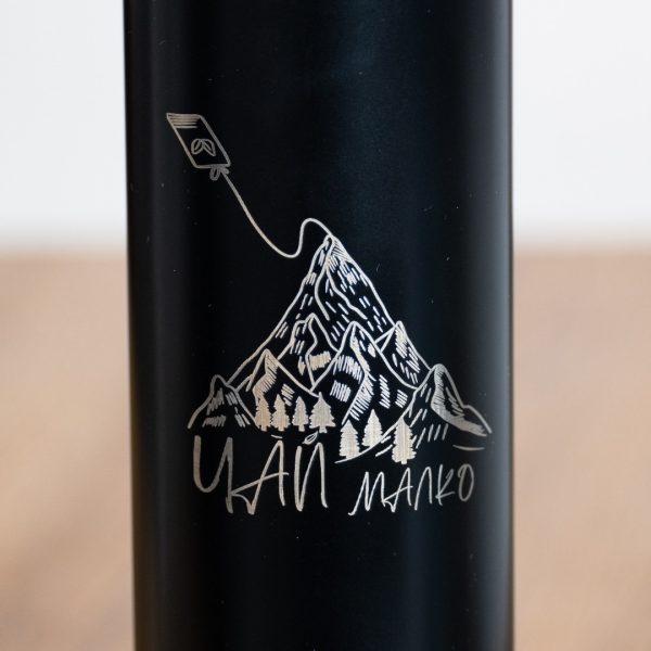 metalen-termos-s-filtar Close-up of laser-engraved mountain and “Chai malko” design on a black thermos.