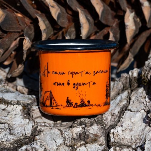 mini-chashka-za-kafe Small orange enamel mug with camping illustration and text “Don’t burn the forest, light the fire in your soul”, placed on bark outdoors.