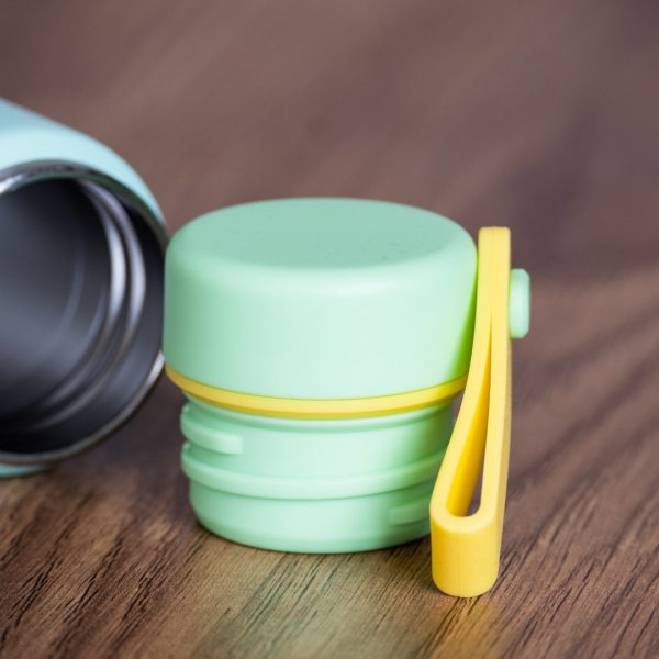 mini-malyk-termos-za-voda Close-up of mint green mini thermos cap with yellow carrying handle.