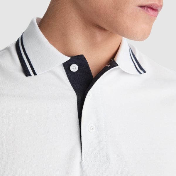 Close-up detail of a premium white cotton polo shirt with navy contrast collar and placket made from heavyweight 230 gsm cotton