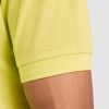 detayl-rakav-lime-polo-teniska-60-pamuk-40-poliester Close-up detail of the sleeve cuff on a lime green polo shirt made from 60 percent cotton and 40 percent polyester showing the ribbed finish and textured pique fabric