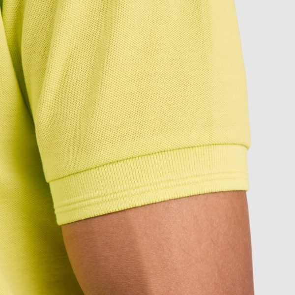 detayl-rakav-lime-polo-teniska-60-pamuk-40-poliester Close-up detail of the sleeve cuff on a lime green polo shirt made from 60 percent cotton and 40 percent polyester showing the ribbed finish and textured pique fabric