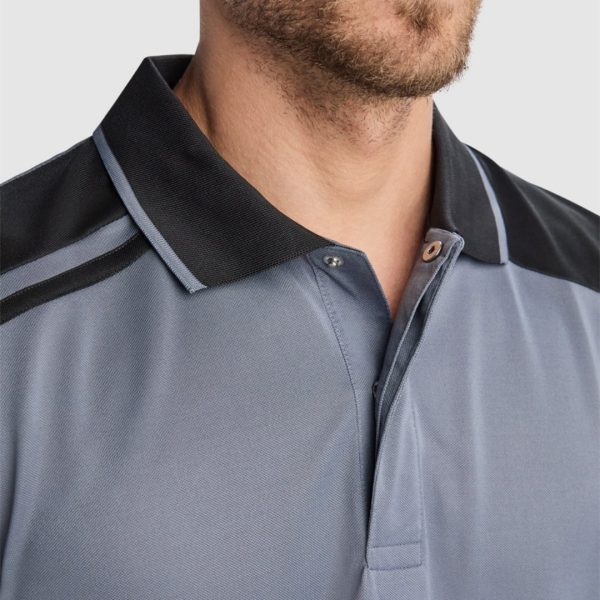 Close-up detail of gray and black polyester polo shirt collar with contrast shoulder panels and modern technical design