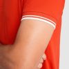 Close-up detail of the sleeve cuff on a premium red cotton polo shirt with white contrast stripes made from heavyweight 230 gsm fabric
