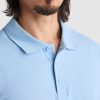 Close-up detail of men's sky blue polo shirt collar made from premium cotton fabric with classic button placket and textured pique material